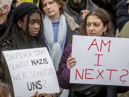 Dos mujeres con carteles en protesta contra la matanza racista, el 22 de febrero en una manifestación en Hanau.