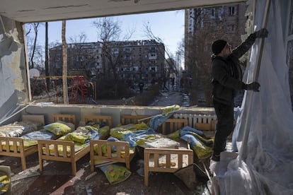 Un hombre retiraba una cortina de una escuela dañada entre otros inmuebles residenciales en Kiev, el 18 de marzo. EE UU ha denunciado que “las fuerzas rusas han destruido edificios de apartamentos, escuelas, hospitales, infraestructuras críticas, vehículos civiles, centros comerciales y ambulancias, y esos ataques han dejado miles de civiles inocentes muertos o heridos”.