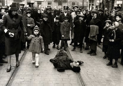 Los transeúntes ignoran a un hombre tirado en la calle en el gueto de Varsovia, Polonia, 1941.