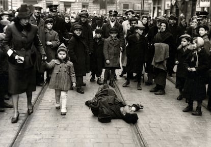 Passersby ignore a man lying on the street in the Warsaw ghetto, Poland, 1941.