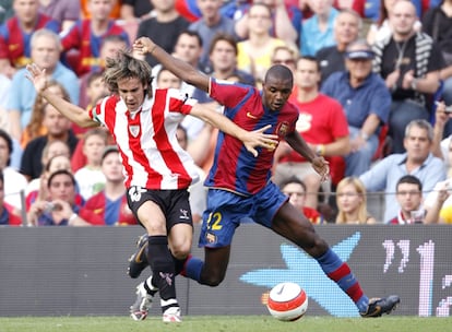 Los jugadores del Athletic tratan de sobreponerse al resultado adverso. En la imagen el bilbaíno López lucha con Abidal por harcerse con el control de la pelota.