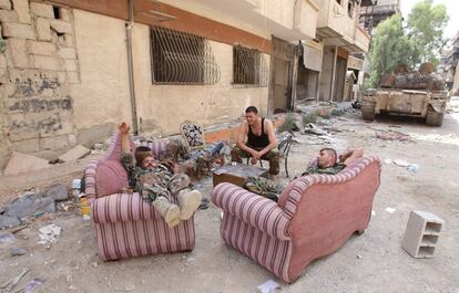 Soldados del Ejército sirio descansan en una calle de Daraya tras su evacuación.