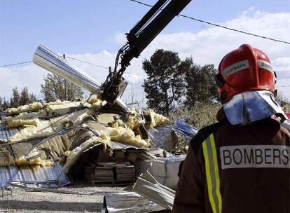 Un bombero contempla los efectos del temporal en una empresa de las afueras de Lleida, donde el viento ha provocado ya graves destrozas.