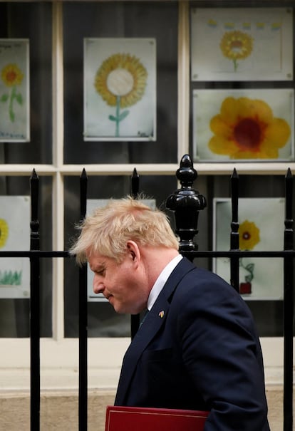 El primer ministro británico, Boris Johnson, camina junto a fotos de girasoles, la flor nacional de Ucrania, en las afueras de Downing Street en Londres, Gran Bretaña.