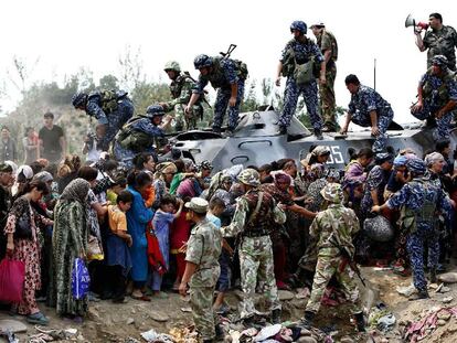 Soldados del Ejército kirguís ayudan a un grupo de refugiados uzbekos en la ciudad de Osh.