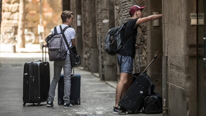 Turistas con sus maletas en una calle de Barcelona.