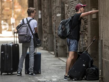 Turistas con sus maletas en una calle del Barrio Gótico de Barcelona.