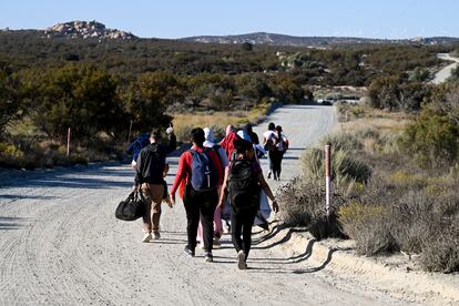 Asylum-seekers walk to a U.S. Border Patrol van after crossing the nearby border with Mexico, Tuesday Sept. 26, 2023, near Jacumba Hot Springs, Calif.