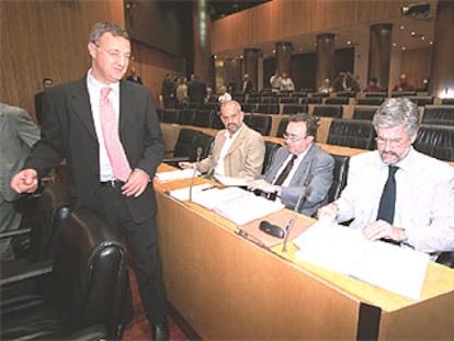 El portavoz del Grupo Socialista, Jesús Caldera (de pie), conversa en el Congreso con otros diputados.