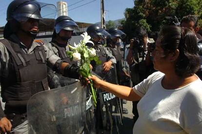 Una simpatizante de la Asamblea Popular de los Pueblos de Oaxaca ofrece unas flores a unos efectivos de la Policía Federal Preventiva en Oaxaca.