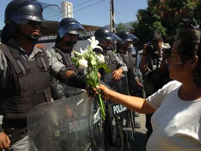Una simpatizante de la Asamblea Popular de los Pueblos de Oaxaca ofrece unas flores a unos efectivos de la Policía Federal Preventiva en Oaxaca.
