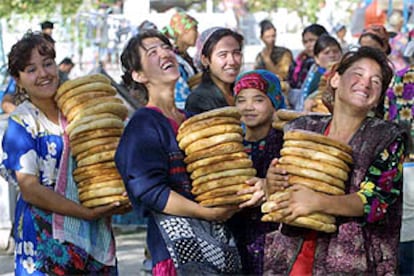 Varias mujeres transportan pan en el mercado de la ciudad uzbeka de Termez, junto a la frontera con Afganistán.