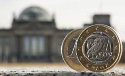 Dos monedas de euro, una de ellas acuñada en Grecia, fotografiadas delante del Bundestag en Berlín. EFE/Archivo