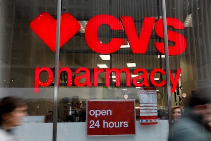 FILE PHOTO: People walk by a CVS Pharmacy store in the Manhattan borough of New York City