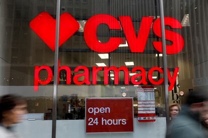 FILE PHOTO: People walk by a CVS Pharmacy store in the Manhattan borough of New York City