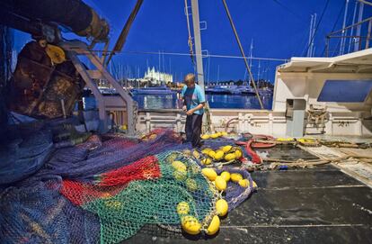 Un pescador limpia sus redes en el puerto de Palma de Mallorca.
