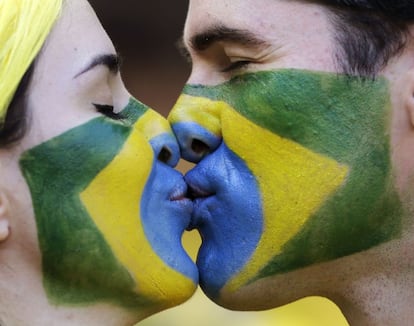 Um casal brasileiro pintado com as cores de sua seleção beijam-se durante a partida disputada contra Chile no Mineirão (Brasil), 28 de junho de 2014.