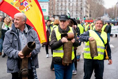 Agricultores y ganaderos sujetan cencerros durante la protesta ante el Ministerio de Agricultura.