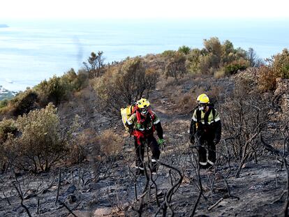 Dos bomberos en un bosque quemado en el incendio de Llançà, en Girona.