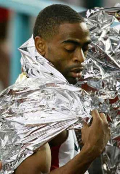 Tyson Gay se protege del frío con una manta térmica tras su carrera.