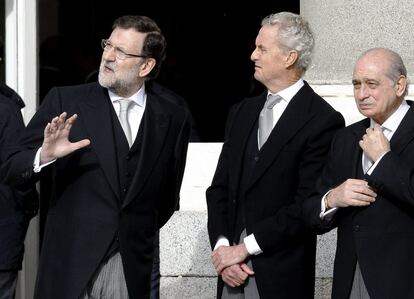 El jefe del Ejecutivo, Mariano Rajoy, y los ministros de Defensa, Pedro Morenés, e Interior, Alberto Fernández Díaz, esperan en la puerta del Palacio Real que se abre a la Plaza de la Armería la llegada del Rey.