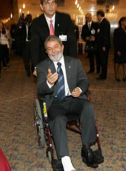 Lula, en silla de ruedas, con su médico, Cleber Ferreira, en Abuja.