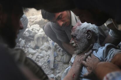 Residente rescatan a un hombre entre los escombros en la ciudad siria de Douma, tras un ataque aéreo.