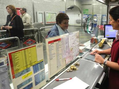 Una taquillera atiende a una pasajera del Metro de Madrid.