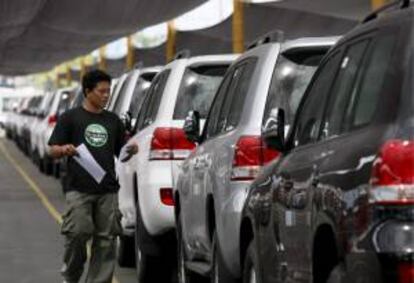 Un empleado recuenta coches nuevos de origen coreano estacionados en la zona portuaria de Manila (Filipinas). EFE/Archivo