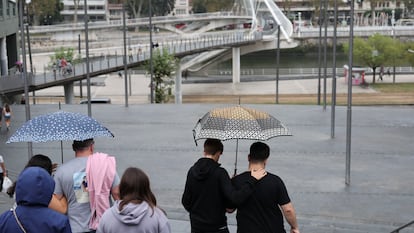 Personas se protegen con paraguas este miércoles en Bilbao.