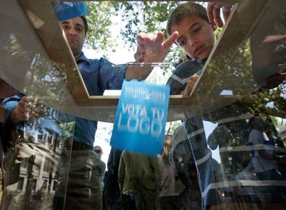 Varios ciudadanos votando ayer su logo preferido para la candidatura olímpica de Madrid.