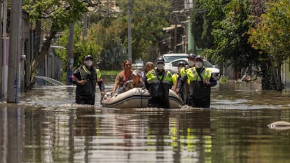 Vecinos de la colonia Culturas de México son transportados por policías tras las inundaciones en Chalco, Estado de México.