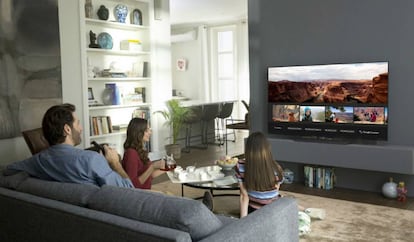 Una familia, frente al televisor inteligente en el salón de su casa.