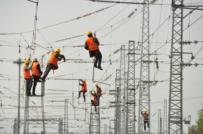 Un grupo de trabajadores instala y revisa cables de electricidad en una estacin de ferrocarril en Ankang (China).