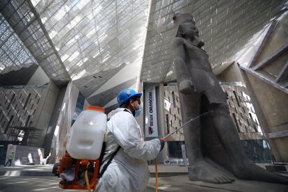 Un miembro de un equipo de limpieza rocía desinfectante como medida de precaución contra el brote de coronavirus, cerca de una estatua gigante del faraón egipcio Ramsés II en una sala del Gran Museo Egipcio en Giza (Egipto), sometida a desinfección.