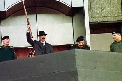Sadam Husein dispara con un rifle para dar la salida a un desfile militar en Bagdad, en diciembre de 2000.