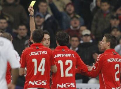 Burrull le enseña una tarjeta amarilla a Juanfran en el partido ante el Real Madrid