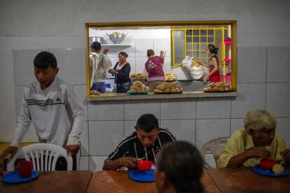 Varios venezolanos desayunan ayer en una parroquia en Pacaraima.