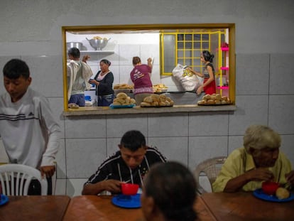 Varios venezolanos desayunan ayer en una parroquia en Pacaraima.