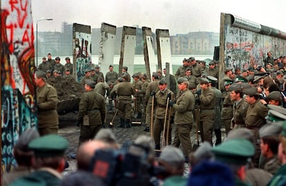 Soldados alemanes del Este y del Oeste de Alemania abren el paso en una de las primeras secciones que fueron retiradas del muro de Berlín; en este caso, cerca de la plaza de Postdamer.
