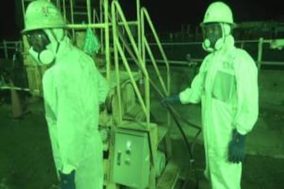 Fotografía tomada el 8 de julio de 2013 y facilitada un día después por la compañía eléctrica Tokyo Electric Power (TEPCO) que muestras a dos operarios junto a maquinaria para la mejora del suelo en la central nuclear de Fukushima Daiichi en Okukma, en la prefectura de Fukushima (Japón). EFE/Archivo