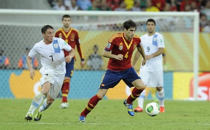 Javi Martínez conduce la pelota ante el uruguayo Cebolla Rodríguez.