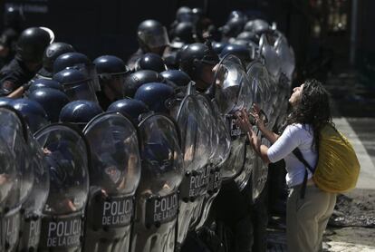 Una manifestante enfrenta a integrantes de la Policía Federal en Buenos Aires (Argentina), el 18 de diciembre. 
