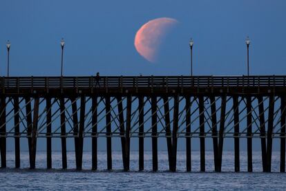 Aspecto de la superluna cuando pasa frente a un muelle en Oceanside (California).