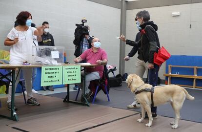 Una mujer invidente, en el momento de votar en un colegio electoral en la localidad vizcaína de Durango, con todas las medidas de seguridad ante la pandemia del coronavirus.