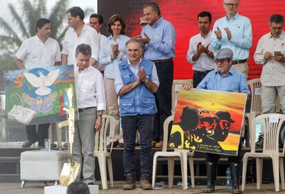 El líder de las FARC, Timochenko (d), y el presidente de Colombia Juan Manuel Santos (i) sostienen obras de arte en conmemoración al fin de las FARC como grupo armado, en Buenavista. 
