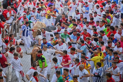 Decenas de corredores participan en el quinto encierro de San Fermín, este viernes.