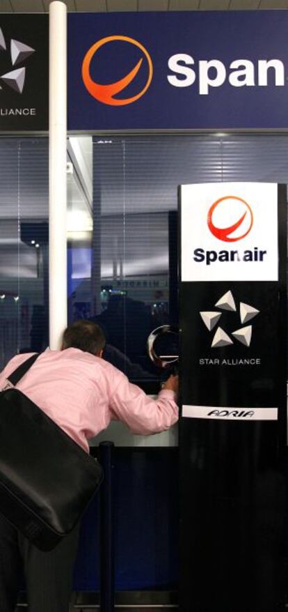Un pasajero requiere informaci&oacute;n en una taquilla de Spanair en El Prat.