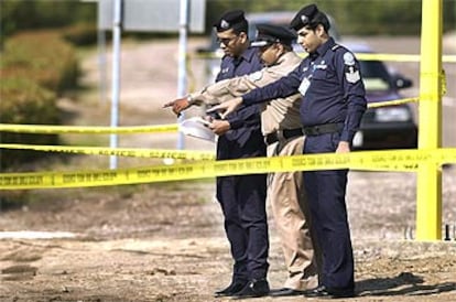 Policías kuwaitíes investigan en el área donde los dos norteamericanos fueron tiroteados cerca de Camp Doha.