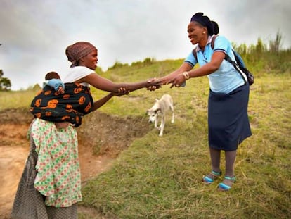 Una trabajadora sanitaria rural saluda a una campesina en la región de El Cabo, en Sudáfrica